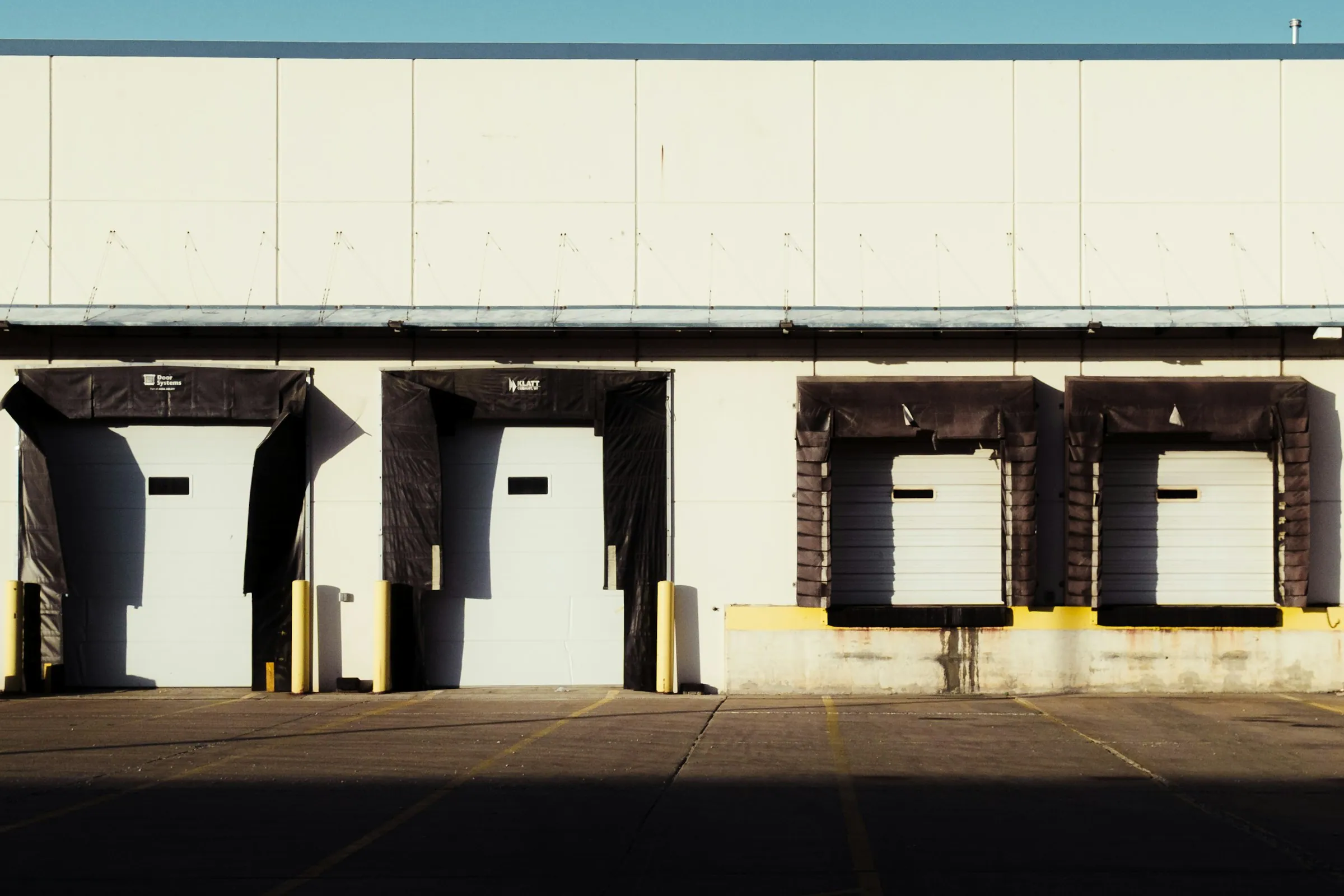 A row of loading dock doors along a commercial building