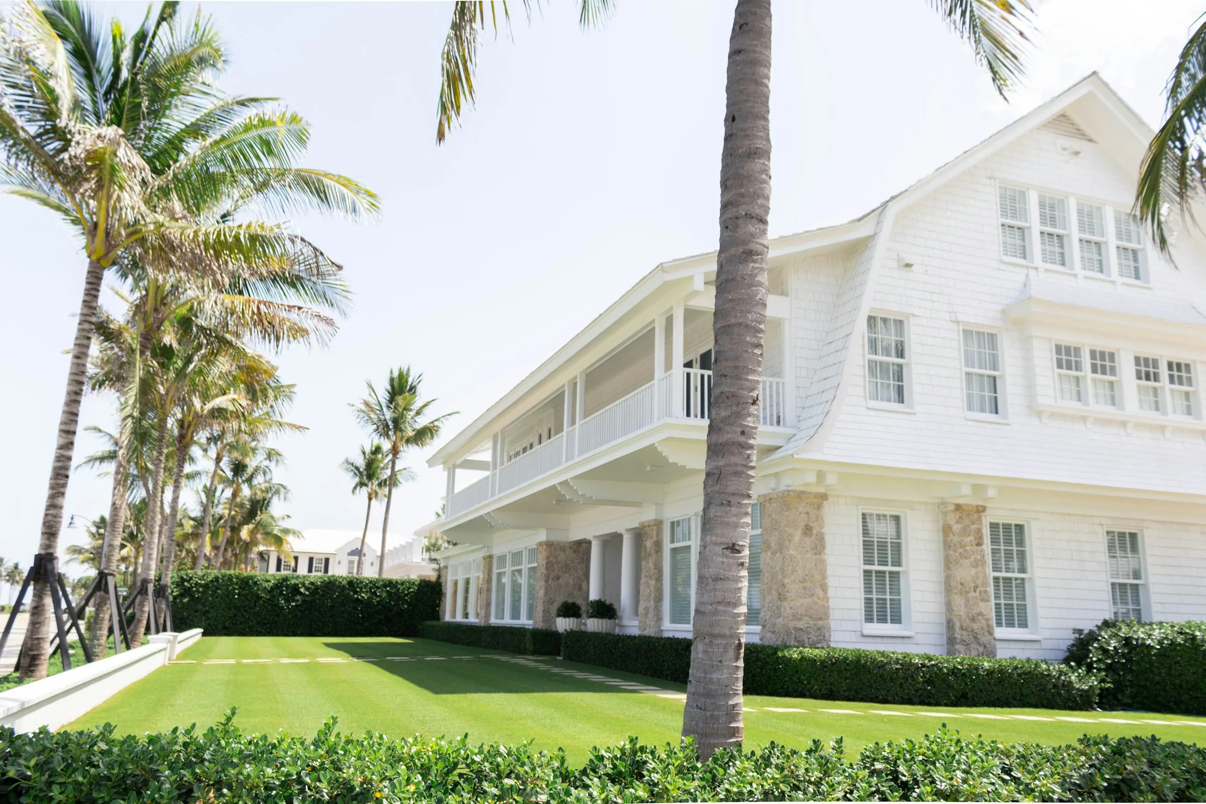 White Florida-style house framed by palm trees
