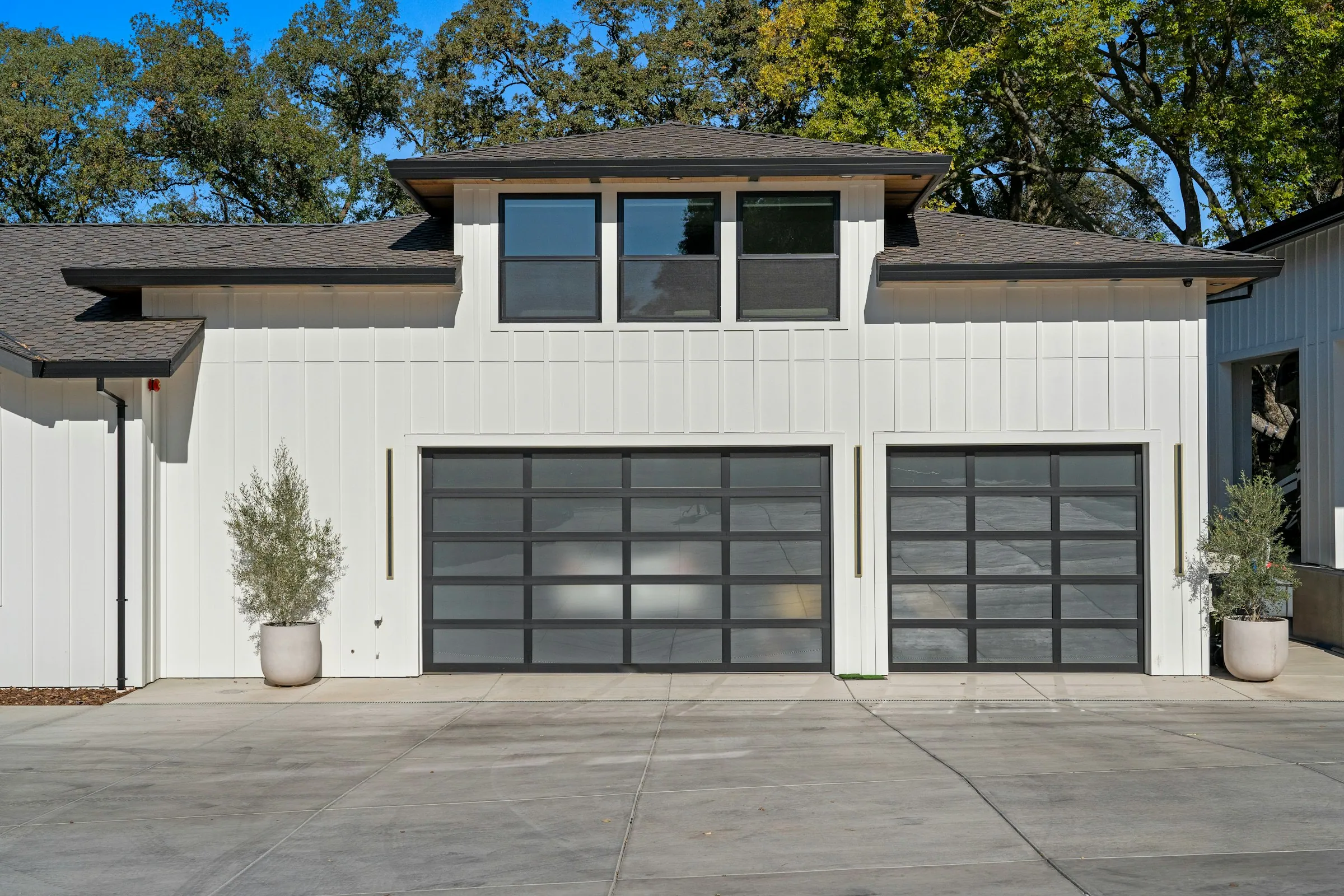 Modern white home with two full-view glass and aluminium garage doors