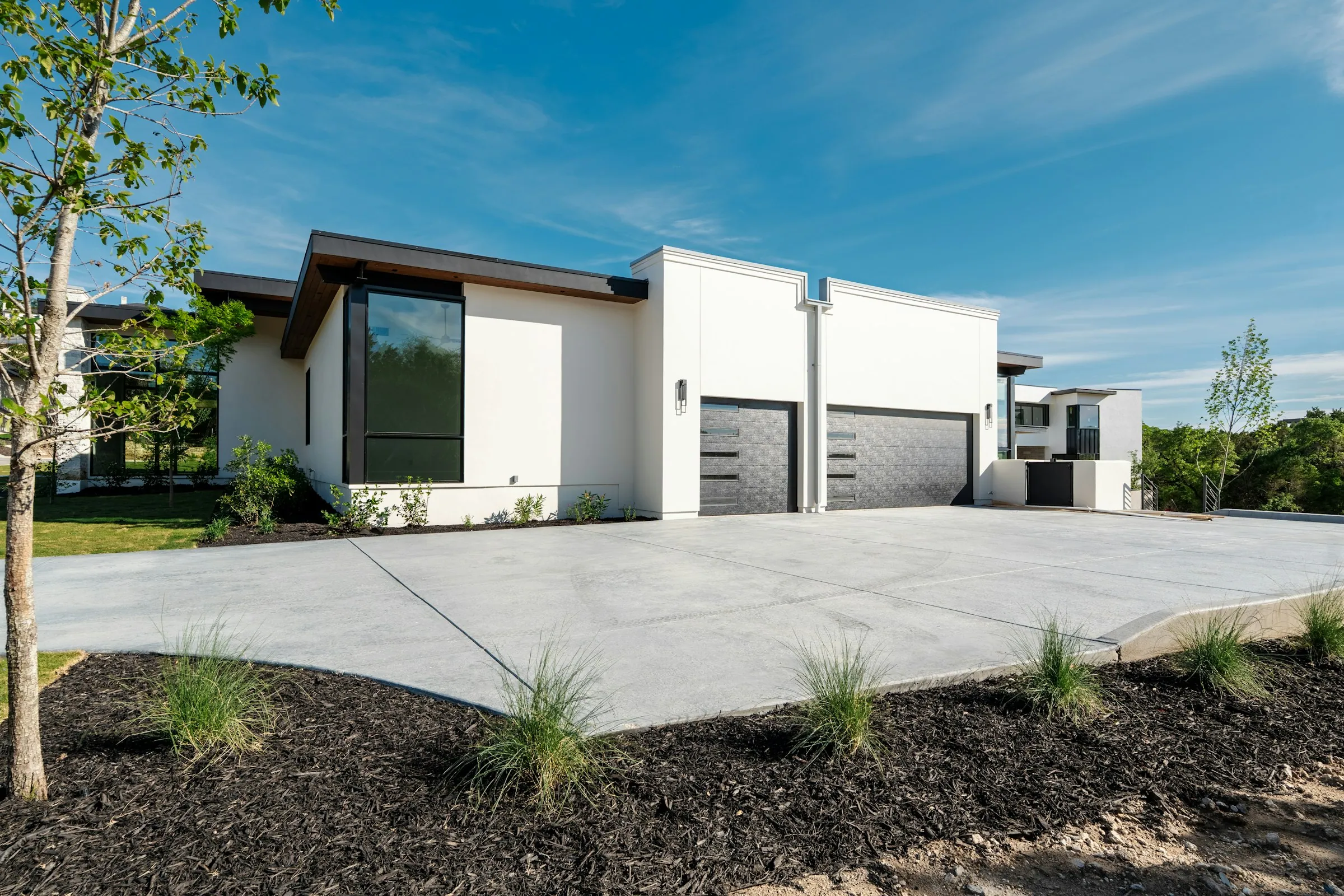 Contemporary house with twin sectional garage doors and a wide concrete driveway