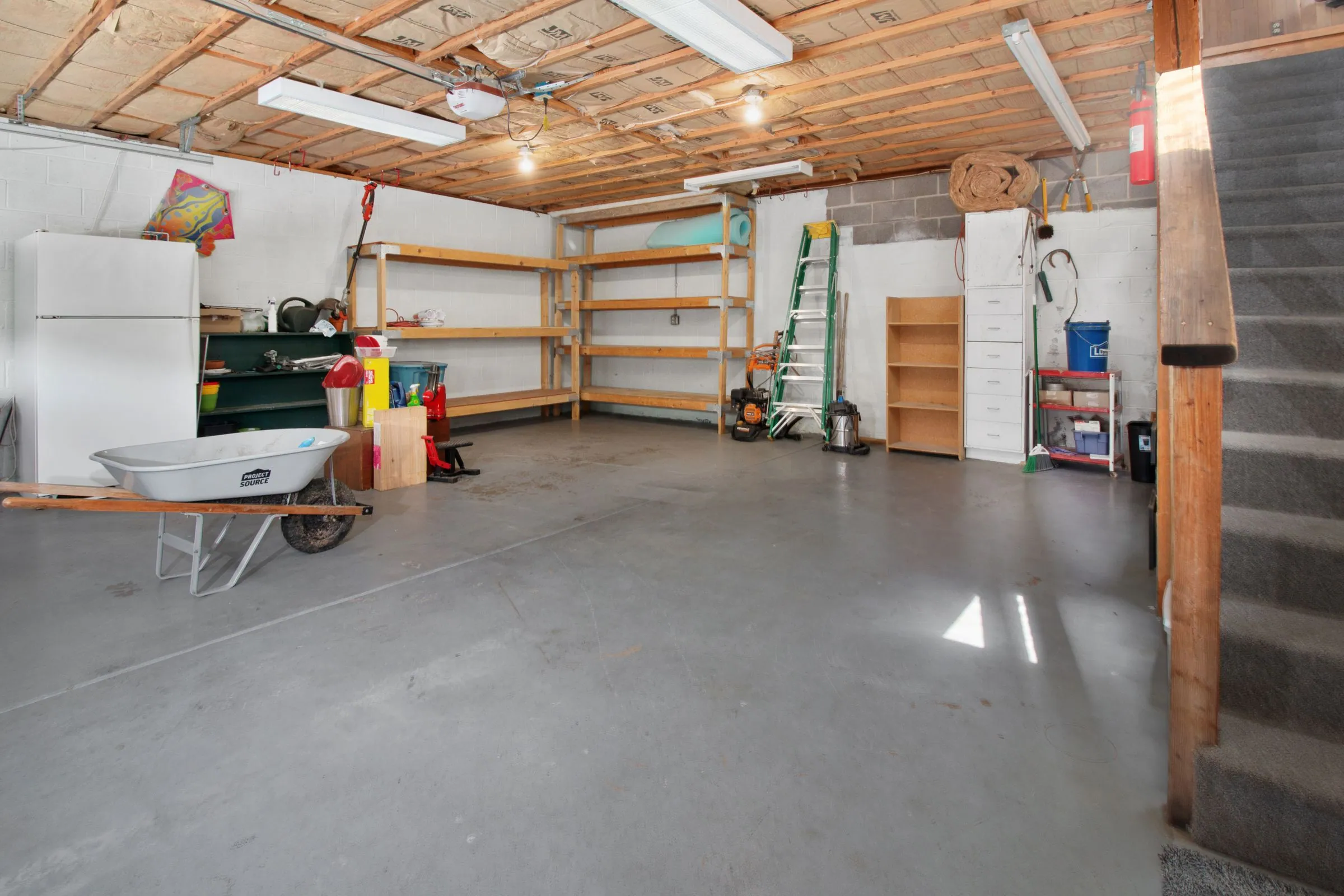 Residential garage interior with storage shelving and tools