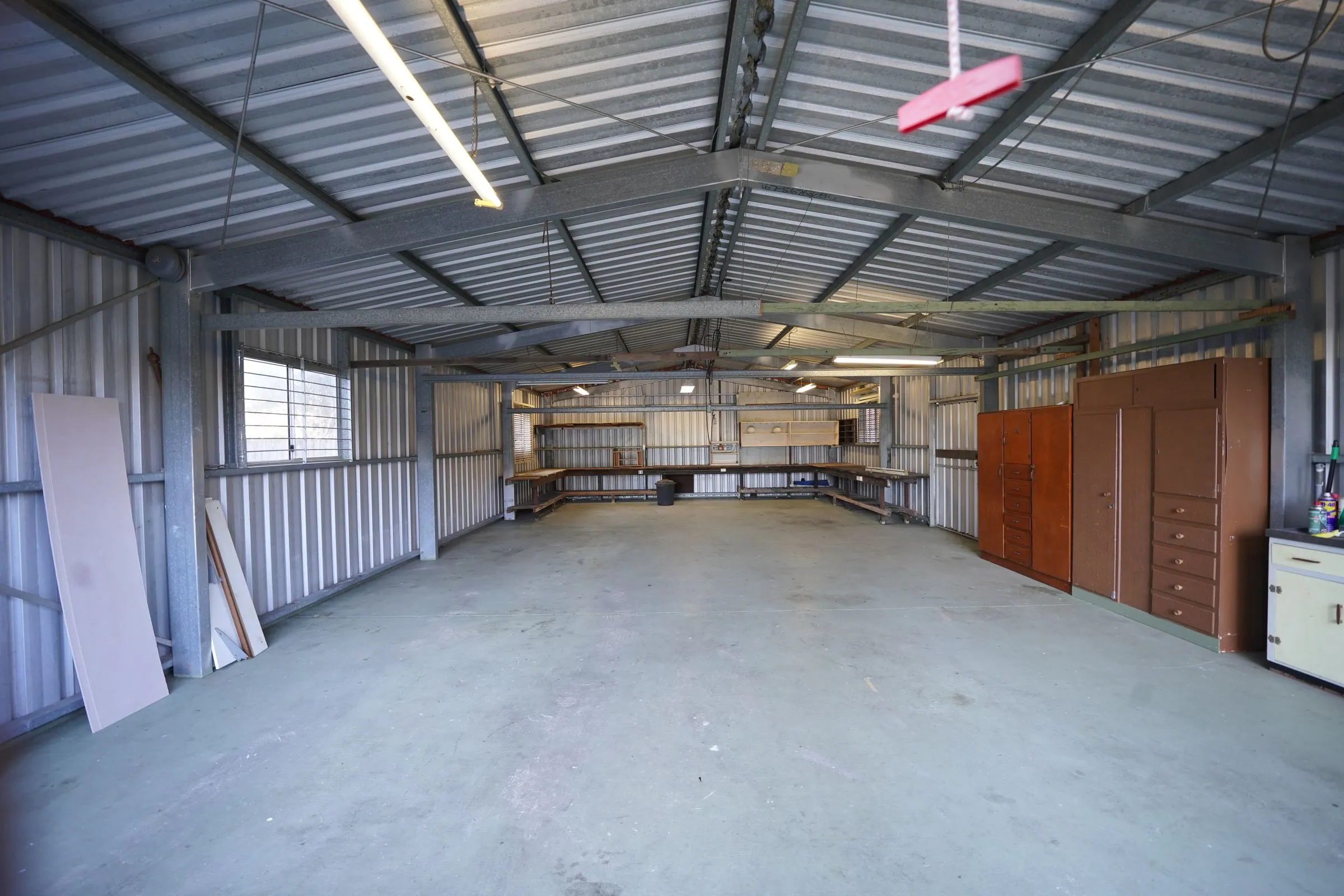 Empty industrial garage interior with metal walls and a concrete floor