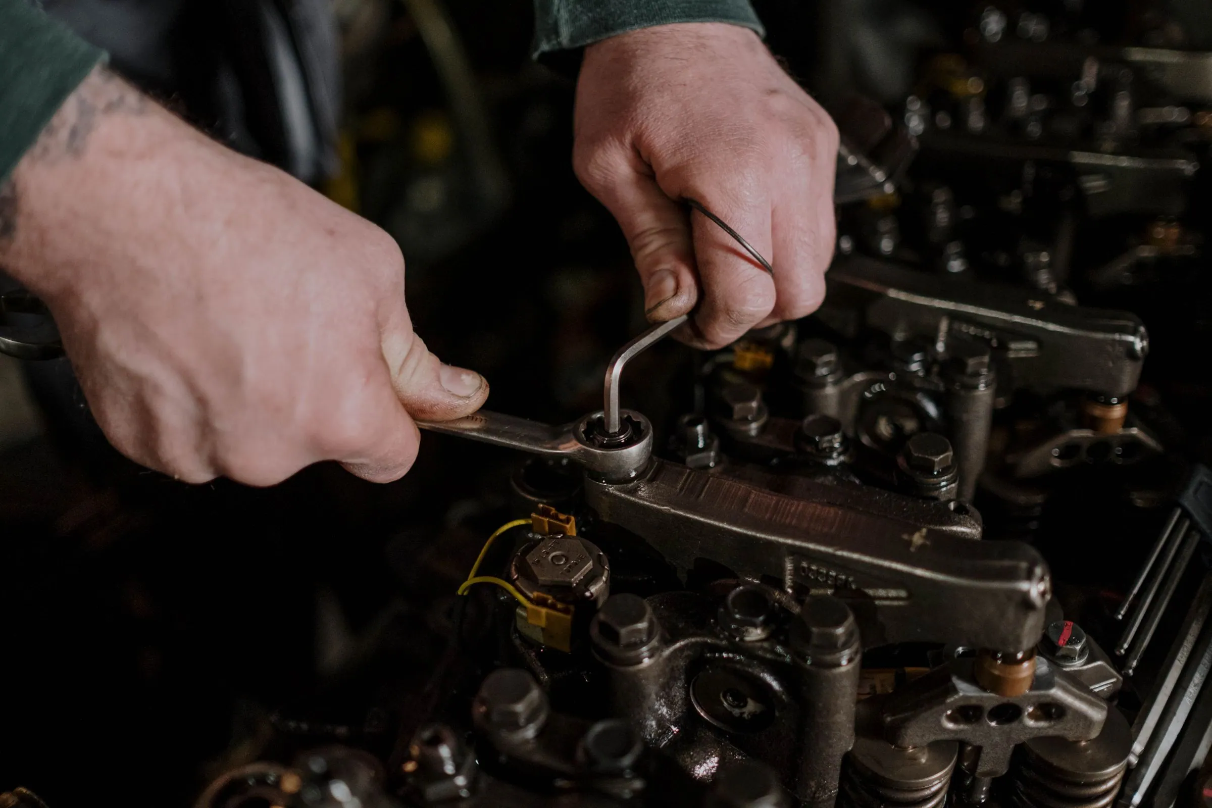 Close-up of hands using a wrench and hex key to make a repair