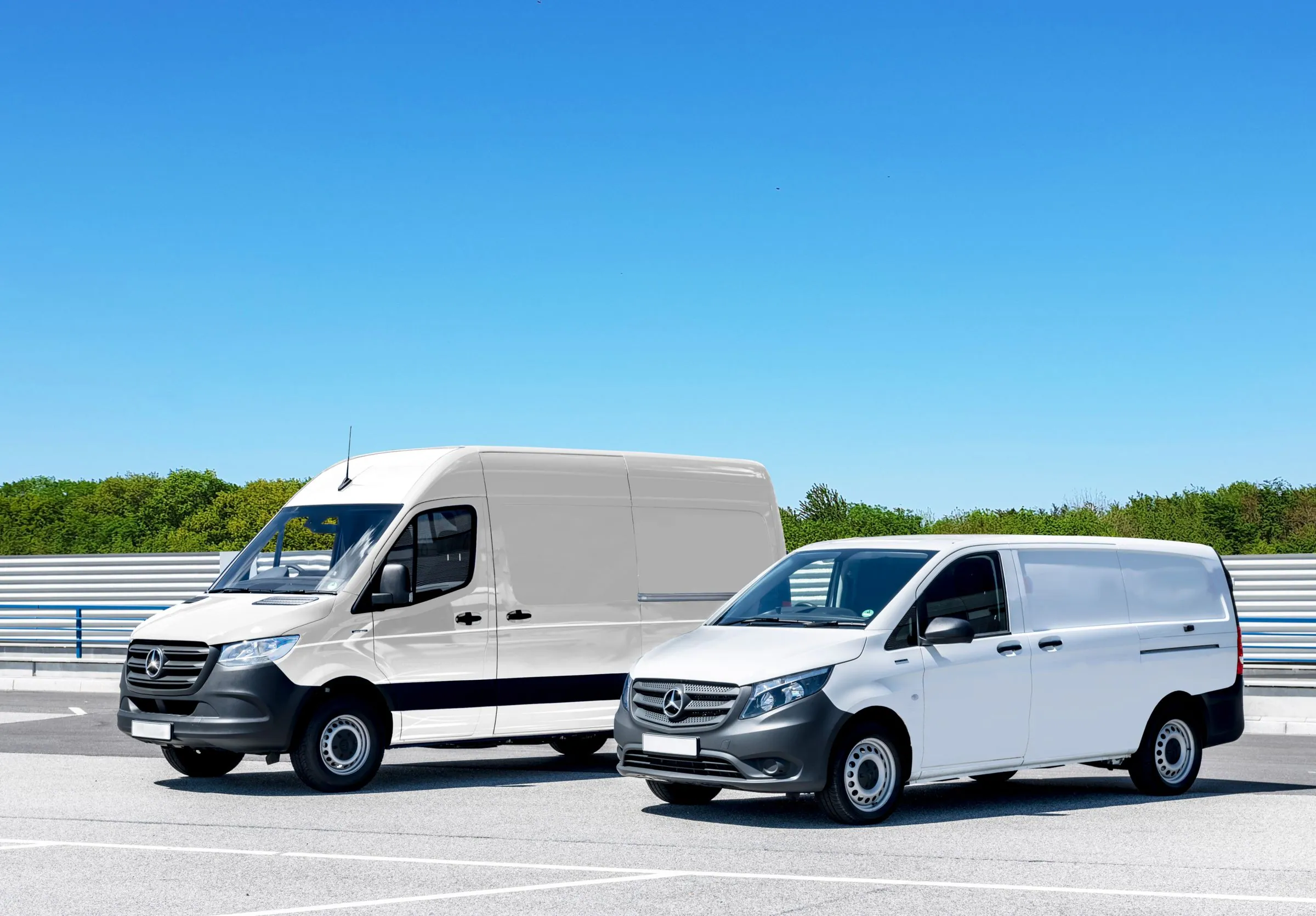 Two white service vans parked under a clear sky