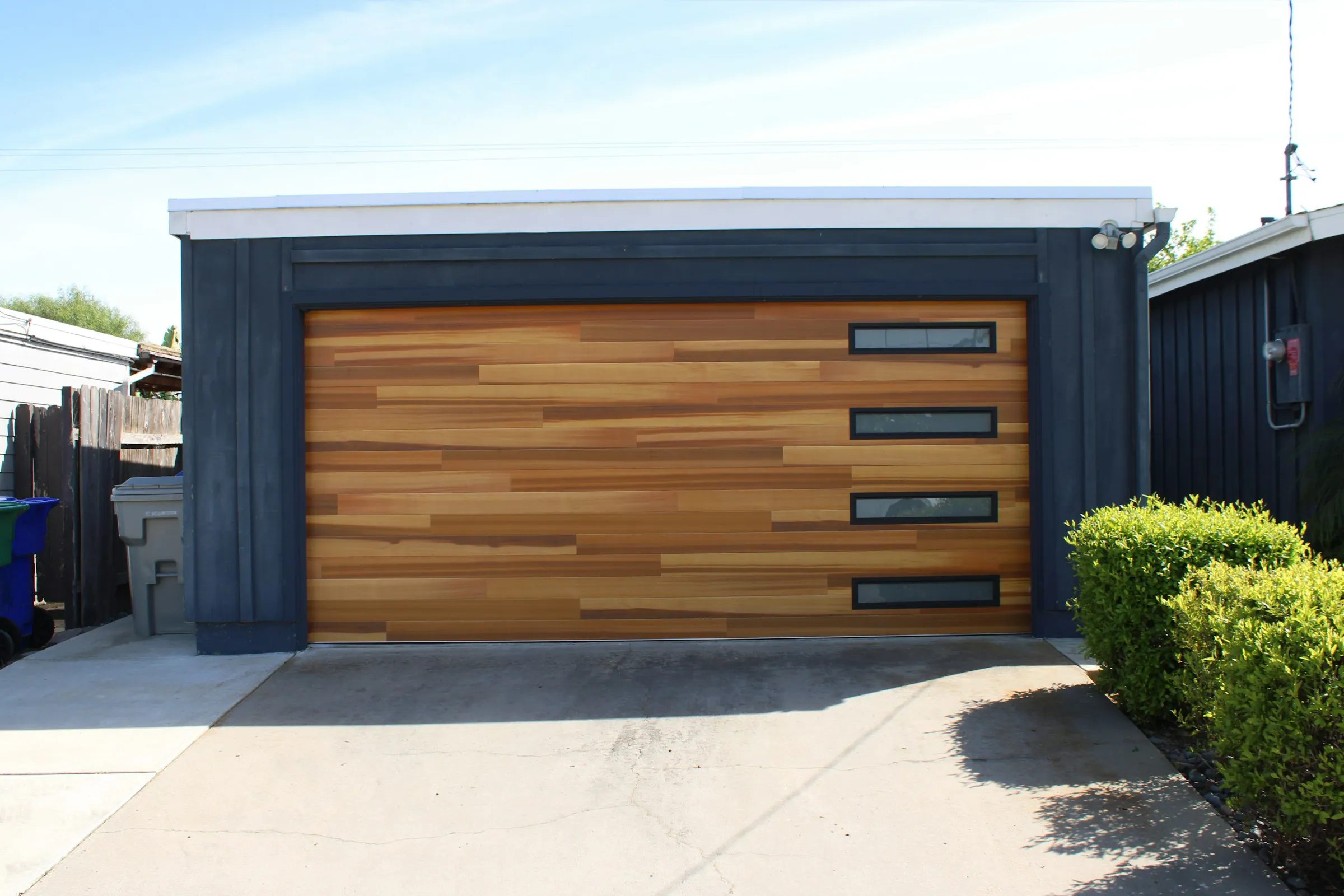 Modern wood-look garage door with a row of glazed window panels